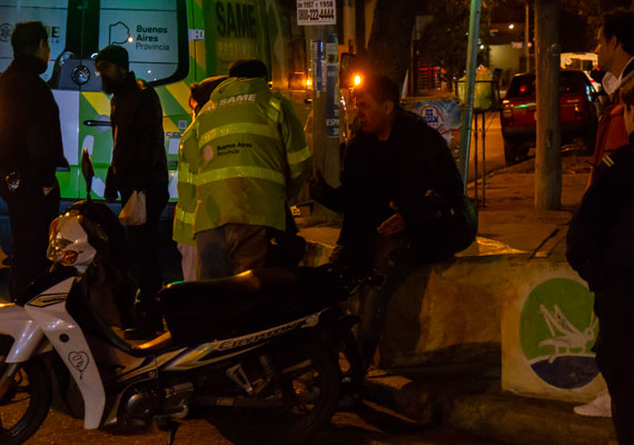 Médicos del SAME (Sistema de Atención Medica de Emergencia) atienden a uno de los accidentados en un choque ocurrido entre dos motocicletas, en la intersección de las calles Olavarria y Cafferata. Personal policial y transeúntes observan la escena. El 17 de junio de 2018 en la localidad de Caseros, Buenos Aires. PABLO FERRAUDI/ARGRA ESCUELA.